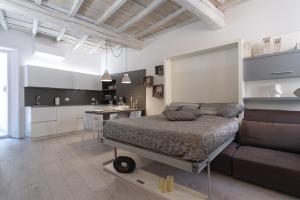 a bedroom with a large bed and a kitchen at Palazzo RICCA GUARDUCCI 1 in Montefiascone