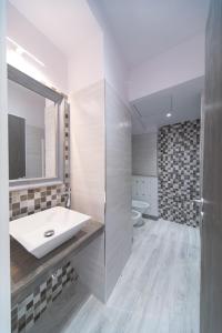 a bathroom with a sink and a mirror and a toilet at Palazzo RICCA GUARDUCCI 1 in Montefiascone +6 photos