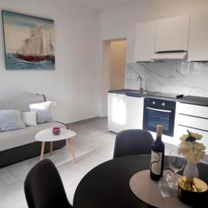 ein Wohnzimmer mit einem Tisch und einer Flasche Wein in der Unterkunft Sea Star Apartments in Pješčana Uvala