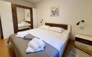 ein Schlafzimmer mit einem großen Bett mit Handtüchern darauf in der Unterkunft Sea Star Apartments in Pješčana Uvala