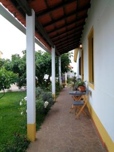 a patio with a table and chairs under a roof at Casa dos Pingos de Mel in Aveiro