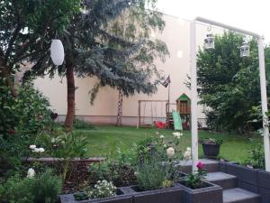 un patio trasero con un jardín con flores y una valla en Ferienwohnung "Kleiner OTTO", en Erfurt