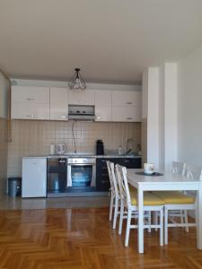 una cucina con tavolo e sedie in una stanza di Apartman M&S a Lukavica