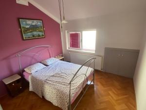 a bedroom with a bed with a pink wall at Gala Posh in Soko Banja