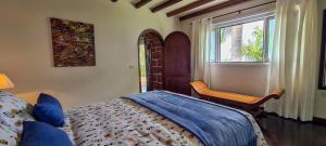 a bedroom with a bed and a window and a chair at CASA LOS POLVEROS in Fuencaliente de la Palma