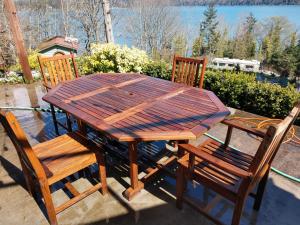 a wooden table and two chairs sitting next to a table and chairs at Sunrise Suite on the Sound in Anacortes