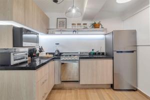 a kitchen with stainless steel appliances and wooden cabinets at MS Loft Suite Moderno Ubicadísimo 150MB 178A in Casa Blanca La Corregidora