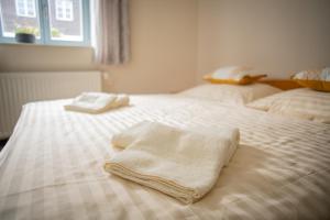 two towels are sitting on a white bed at Stará Celnice Kvilda in Kvilda