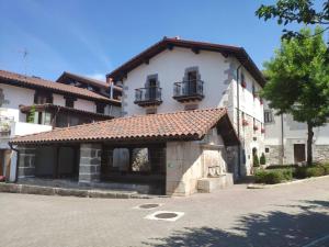 a large white building with a tile roof at Alojamiento Rural URGAIN I y II in Lekunberri