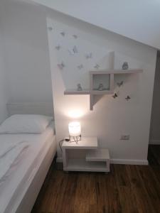 um quarto com uma cama e uma mesa com um candeeiro em Apartmani Kiko em Porec