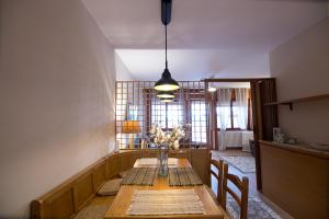 a dining room table with a vase of flowers on it at Relax tra lago e parco in Lesa