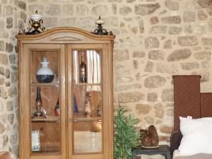 a wooden cabinet in a room with a stone wall at Zupan B studio apartman Krk in Krk