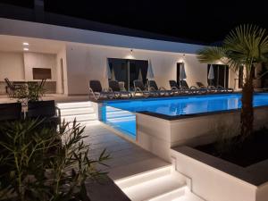 a swimming pool in a house with chairs around it at Villa Medak in Makarska