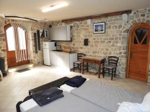 a kitchen and a living room with a bed and a table at Zupan B studio apartman Krk in Krk