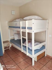 a couple of bunk beds in a room at Maisonnette mitoyenne 2 étoiles paisible piscine océan lac vélo marche idéal pour tous in Lacanau-Océan