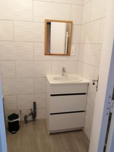 uma casa de banho com um lavatório e um espelho em Appartement proche mer et plage em Douarnenez