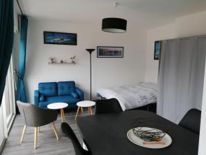 uma sala de estar com um sofá azul e uma mesa em Appartement proche mer et plage em Douarnenez