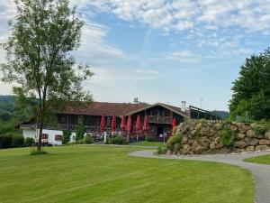 a large building with a stone wall in front of it at Golfchalet Uttlau in Bad Griesbach