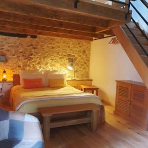- une chambre avec un lit et un banc dans l'établissement Rouet Nature, à Tréban