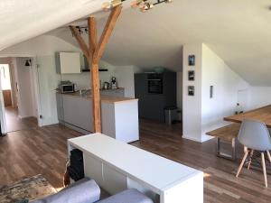 een woonkamer met een tafel en een keuken bij Ferienwohnung Samys nahe Lindau am Bodensee in Sigmarszell
