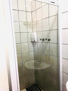 VnA Guesthouse في نيوكاسل: دش في حمام مع باب زجاجي