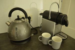 a tea kettle and two cups on a counter at DINOS - Whole guesthouse - Nearby Groningen and lake in Eelderwolde