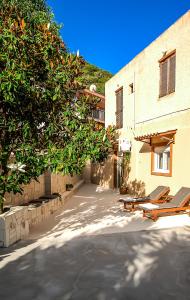 un patio con 2 tumbonas y un árbol en Apartment close to Balos-Elafonisi and Falasarna! en Kámbos