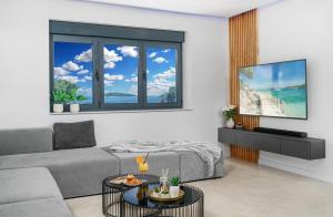 Una sala de estar con un sofá y un televisor. en Villa Gray, en Tribunj