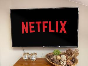 a television screen with the netflix sign on a table at Bronowicka Premium Apartment - 52m2 with private parking in Kraków