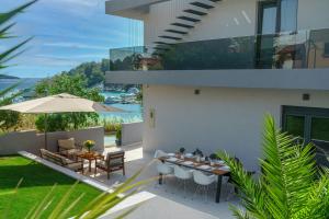 Un patio con una mesa y sillas y una sombrilla. en Villa Gray, en Tribunj