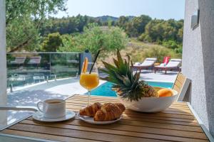 Una mesa con un vaso de jugo de naranja y un tazón de comida. en Villa Gray, en Tribunj