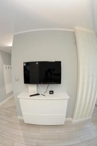 a flat screen tv sitting on top of a white cabinet at Osiedle Centrum Miasta in Suwałki