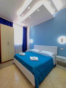 ein blaues Schlafzimmer mit einem Bett mit Handtüchern darauf in der Unterkunft Al Mare in Gallipoli