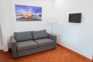 una sala de estar con sofá y una pintura en la pared en Terre di Monacella, en Santa Venerina