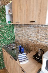 een keuken met een wastafel en een aanrecht bij Linett Apartman in Hajdúszoboszló +37 foto's