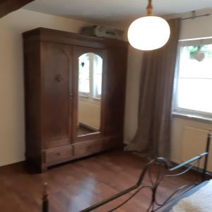 a room with a wooden cabinet and a window at Am Hohestein in Briedeler Heck