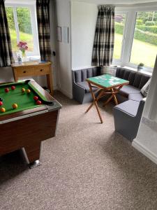 a living room with a pool table and a couch at Garth- Stunning Scenic semi-rural Cottage with Games room in Conwy