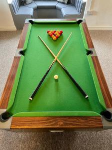 a green pool table with balls on top of it at Garth- Stunning Scenic semi-rural Cottage with Games room in Conwy