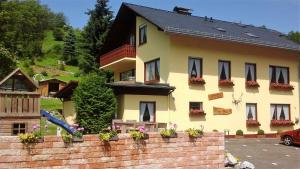 a large yellow house with windows and a brick wall at Appartement 5 Willingen in Willingen