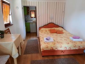 a small bedroom with a bed with towels on it at Apartmani Jovanovic in Perućac