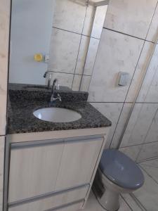 uma casa de banho com um lavatório e um WC em CASA TEMPORADA - PARA 05 PESSOAS em Trindade