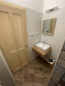 a bathroom with a sink and a mirror and a door at Safit-Mandala in Mosonmagyaróvár