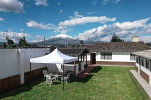 eine Terrasse mit einem Tisch und Stühlen sowie ein weißes Zelt in der Unterkunft La casa de los abuelos in Lasso