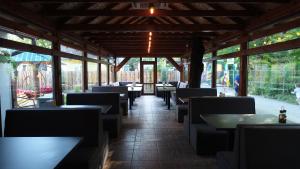 a dining room with tables and chairs and windows at Pansionat Fortuna in Lebedevka