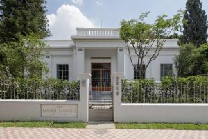 a white house with a gate and a fence at Casa Bosque Eduviges in Guadalajara