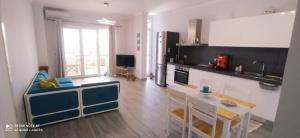 a kitchen with a table and a blue couch at Villa Santa Maria in Vlorë