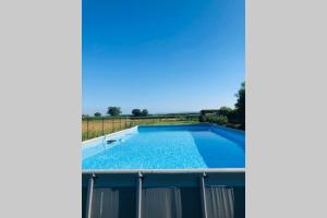 a large swimming pool with blue water on top of a building at La casa nei campi in Badia Pavese