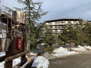 una calle cubierta de nieve con un edificio en el fondo en Cosy appartement au calme à deux pas du centre, en Auron