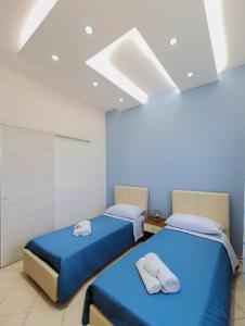 two beds in a room with blue sheets at Al Mare in Gallipoli