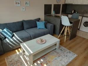 uma sala de estar com um sofá e uma mesa em До морето em Burgas